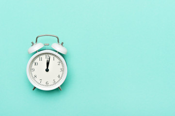 Vintage alarm clock isolated on pastel mint background