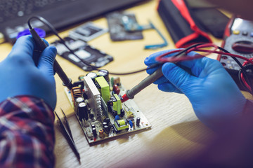 Professional repairman repairing computer in workshop.