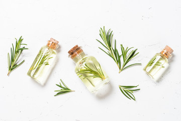 Rosemary essential oil in the bottle on white.