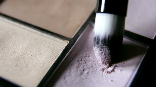 A woman holds the cosmetics. Make up palette set and brush. Professional multicolor eyeshadow make-up palette background, close-up. Beauty, makeup and fashion concept