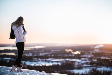 Blonde Girl on Top of Mountain in Winter Sunset