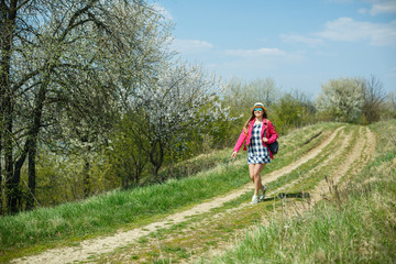 Obraz premium beautiful girl in a dress walking in the spring forest where the trees bloom