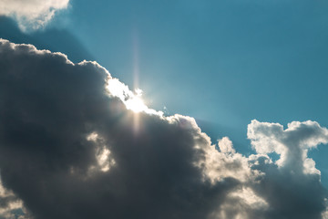 dark clouds covering the sun and blue sky. fast weather change
