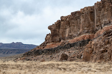 Banded Volcanic Rock Outcroppings cromposed of different colored layers of solidified volcanic flows in White River Narrows, Basin and Range National Monument, Nevada.