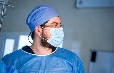 Specialist in medical uniform during an operation in hospital. Modern hospital operating room.