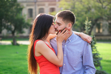 Beautiful couple of man and woman sitting on a bench in a park. Romantic theme with a girl and a guy. Spring Summer theme  relationship, love, Valentine's day