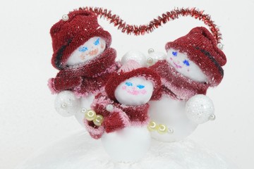 Obraz na płótnie Canvas snowman family parents with children during snowfall