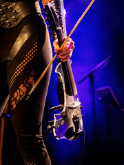 Electric violin in the hands of a beautiful woman musician, rock concert