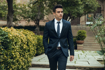 Young boy with suit walking through garden