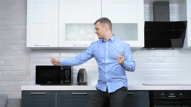 young handsome man dancing in the kitchen. lifestyle