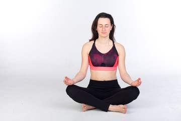 Fototapeta premium woman in leggings and sports bra is stretching and practicing yoga