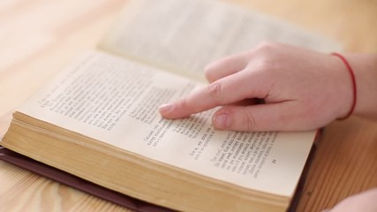 A child is reading a book in the library, a girl is a diligent student sitting and learning school lessons