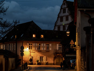 Glowing warm homely windows in a small Alsatian village. Comfort and warmth at home on a winter evening.