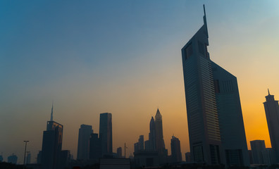 Dubai buildings in sunset dusk, silhouettes of city skyscrapers, United Arab Emirates.