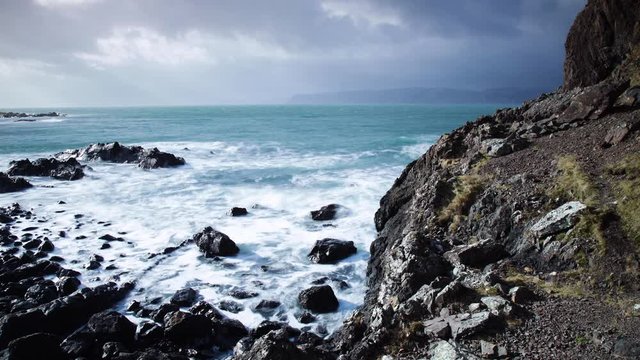 footage of the atlantic ocean as it meets the Isle of Seil on the west coast of scotland in the argyll and kintyre region showing waves pounding on the shore