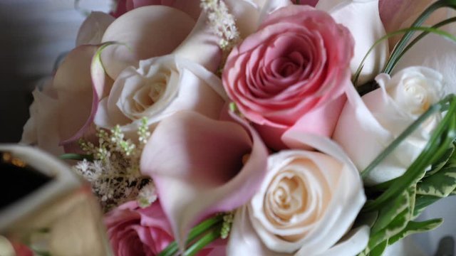 Floral arrangement with one pink rose in the middle of the white roses.  Beautiful wedding bouquet, close up shot