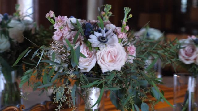 Bouquets with light pink roses and green leaves in front of the mirror in the bride's room. Close up parallax  shot