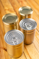 Can of cans on a kitchen wooden table. Preserved food in the household.