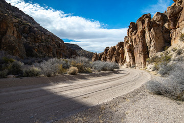 The dirt road through Wrong Way Canyon curves close to the towering volcanic rocks on either side in the Valley of Faces.