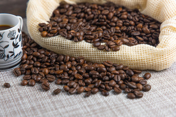 Coffee beans in coffee bag with two white cups and space for text