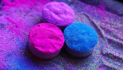 Colorful holi powder in bowls isolated on dark background. Space for text.