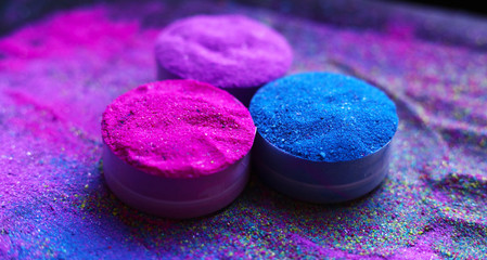 Colorful holi powder in bowls isolated on dark background. Space for text.