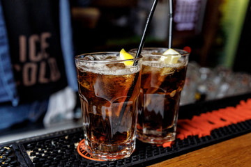 glass of cola with ice on wooden table