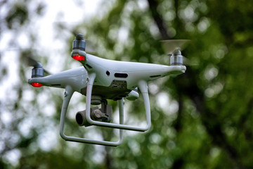 White drone quadcopter taking off from the ground. Soft focus. Motion blur.