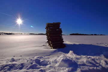 Blue sky with sun over snowy fields