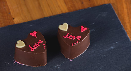 Two heart-shaped chocolate cakes written LOVE.