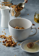 Homemade granola from mix of oat cereals  with dry fruits, nuts and seeds on a grey  concrete table concept of healthy breakfast. Slow living