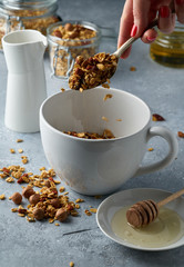 Homemade granola from mix of oat cereals  with dry fruits, nuts and seeds on a grey  concrete table concept of healthy breakfast. Slow living