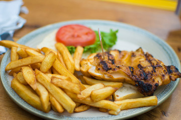 Chicken and chips with a side of lettuce and tomatoes