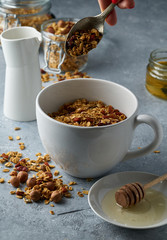Homemade granola from mix of oat cereals  with dry fruits, nuts and seeds on a grey  concrete table concept of healthy breakfast. Slow living