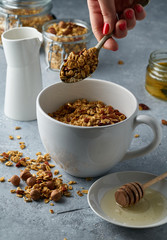 Homemade granola from mix of oat cereals  with dry fruits, nuts and seeds on a grey  concrete table concept of healthy breakfast. Slow living