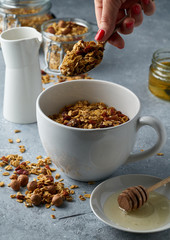 Homemade granola from mix of oat cereals  with dry fruits, nuts and seeds on a grey  concrete table concept of healthy breakfast. Slow living