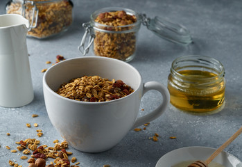 Homemade granola from mix of oat cereals  with dry fruits, nuts and seeds on a grey  concrete table concept of healthy breakfast. Slow living