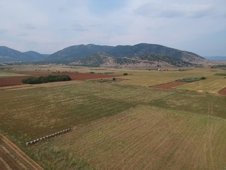 Fototapeta na wymiar Aerial drone landscape photo from high above of fields in a clear weather summer day in the outskirts of Drama, Greece