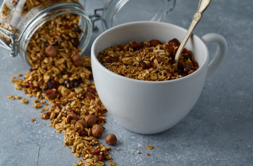Homemade granola from mix of oat cereals  with dry fruits, nuts and seeds on a grey  concrete table concept of healthy breakfast. Slow living