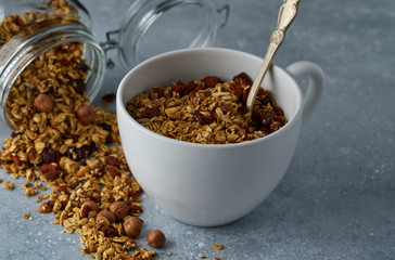 Homemade granola from mix of oat cereals  with dry fruits, nuts and seeds on a grey  concrete table concept of healthy breakfast. Slow living