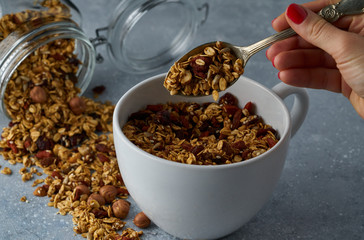 Homemade granola from mix of oat cereals  with dry fruits, nuts and seeds on a grey  concrete table concept of healthy breakfast. Slow living