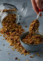 Homemade granola from mix of oat cereals  with dry fruits, nuts and seeds on a grey  concrete table concept of healthy breakfast. Slow living