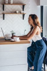 Woman using laptop while sitting at home.