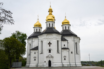 Orthodox Catherine's church with golden domes in Chernihiv, Ukraine. White temple in the Ukrainian Baroque style meets guests at the entrance to Chernihiv 