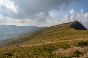 Obraz premium Steep hillsides of Mountain ranges and treking road on Svydovets ridge. Lovely summer scenery of Carpathian mountains. Wonderful nature background 