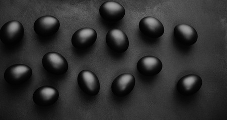 Black eggs on a black background. Easter minimalistic concept