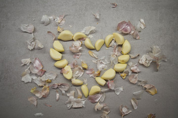 Fototapeta na wymiar cloves of garlic folded in the form of a heart on a gray kitchen table top view