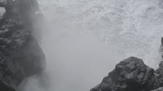 slow-mo of water crashing into rock wall