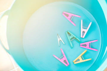 A laundry bucket with flare light and the clothespins inside. 