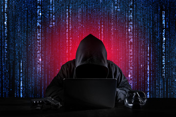 Dangerous hacker man in black hooded, masked and gun using computer, breaking into security data...